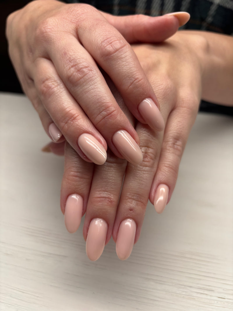 Close-up of hands with pink nail polish on a light surface luminary balance 