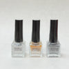 Mable Liquid nail polish in three shades: clear, gold, and gray with black caps on white background